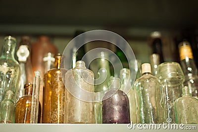 Collection of old dusty colored bottles of different shapes, sizes Stock Photo