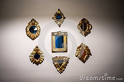 Collection of small mirrors hanging on the wall with golden vintage frames. Stock Photo