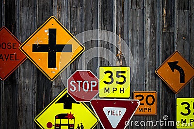 Collection of various road signs on rustic wooden wall Stock Photo