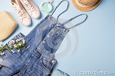 Collection of womens summer clothes and accessories collage on blue. Jeans overall and wicker hat, flat lay Stock Photo
