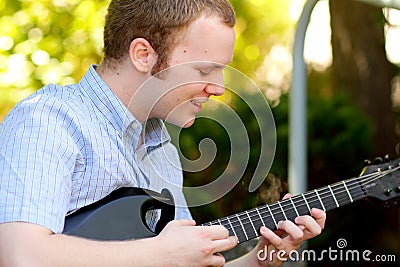 College Boy Concentrating on Guitar Stock Photo