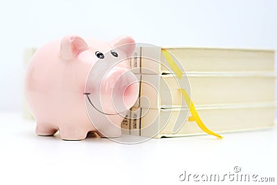 College fund concept with piggy bank standing near a pile of books Stock Photo