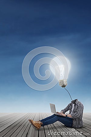 College student with lamp head using laptop Stock Photo