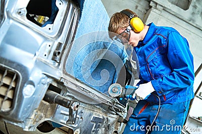 Collision repairs service. mechanic grinding car body by grinder Stock Photo