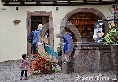 Colmar, France, August 31, 2020: Caucasian man with his daughters and wearing protective covid-19 face mask. Touristy spots in the Editorial Stock Photo