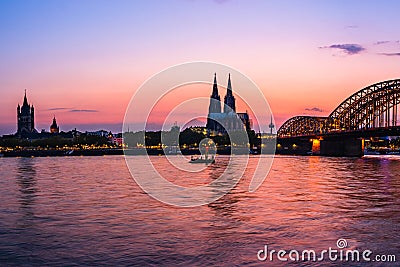 Evening silhouette skyline landscape of the gothic Cologne Cathedra, Hohenzollern railway and pedestrian bridge, the old town and Stock Photo