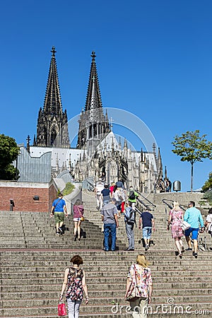 People on the stairs against the backdrop of the towers of the Cologne Cathedral Editorial Stock Photo