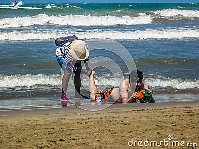 Colombian Girl Giving a Massage at the Beach Editorial Stock Photo