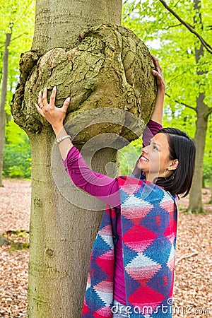 Woman holding cancerous tumor on beech tree Stock Photo