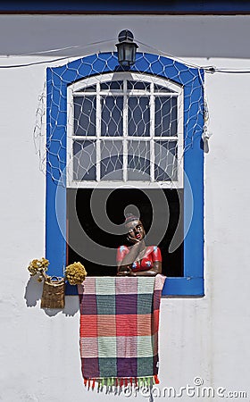 Colonial window with handicrafts, painted ceramic sculpture, called Namoradeira, sweethearts, Ouro Preto, Brazil Editorial Stock Photo