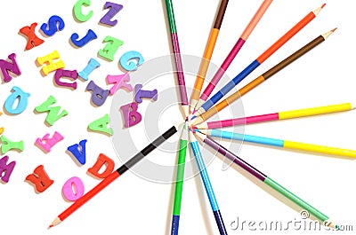 Color letters of the English alphabet. Next to them are colored pencils. Top view. Teaching children Stock Photo