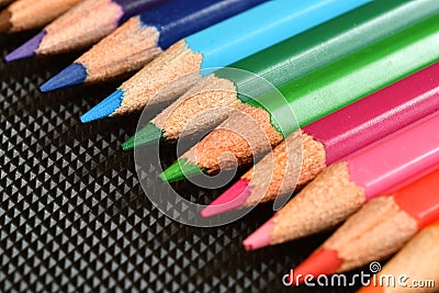 Color pencils on black rubber background. Close-up Stock Photo