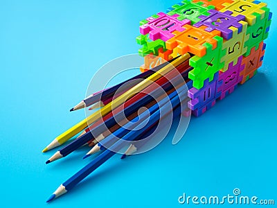 The color pencils in colorfull of pencil holder make form puzzle number on blue background. Concept of education. copy space for t Stock Photo