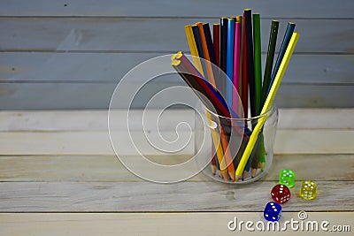 Color pencils glass jar colorful acrylic dice wooden rustic background Stock Photo