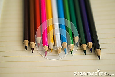 Color pencils on white notebook background.Close up. Stock Photo