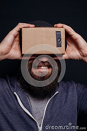 Color shot of a young man looking through card board Stock Photo