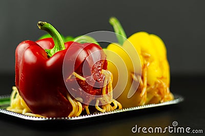 Color stuffed peppers with scary cutout faces, halloween party f Stock Photo