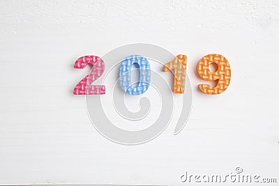 Color toy foam numbers in 2019 on bright wooden surface Stock Photo