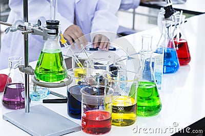 Color water in test tube and beaker near microscope at laboratory Stock Photo