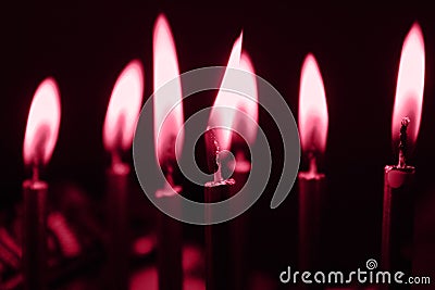 Color of year 2023 Viva Magenta. Image with lots of candles on the birthday cake in the dark is toned in pantone color of viva Stock Photo