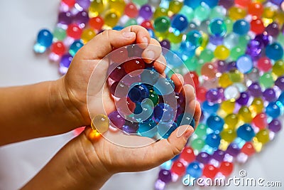 Colored balls of hydrogel in children`s palms Stock Photo