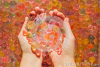 Colored balls of water beads, hydrogel in in hands. Sensory experiences Stock Photo