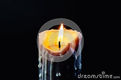 Colored candle with drips of wax burns in the dark Stock Photo