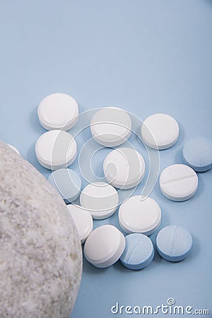 Colored capsules out of cover. Colored capsules with a simple background next to flower leaves or a round stone. Stock Photo