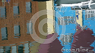 Colored and distorted water reflections of houses and boats Stock Photo