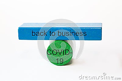 Colored fragments in fragile balance to underline the choice with the words: back to business COVID-19 Stock Photo
