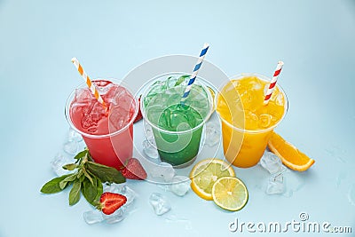 Colored lemonades in plastic cups with ice, fruits and berries Stock Photo