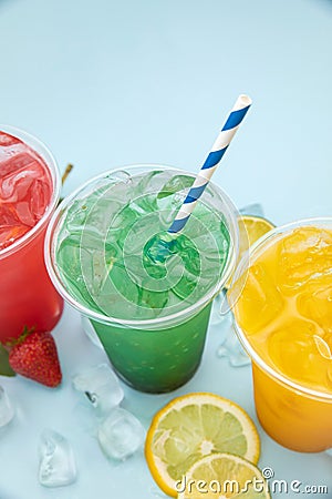 Colored lemonades in plastic cups with ice, fruits and berries Stock Photo
