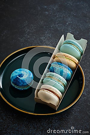 Colored macaroons on a dark background. Copy space. Stock Photo