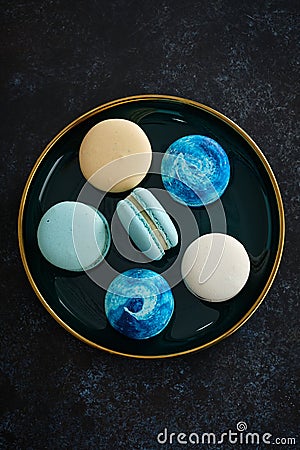 Colored macaroons on a dark background. Copy space. Stock Photo