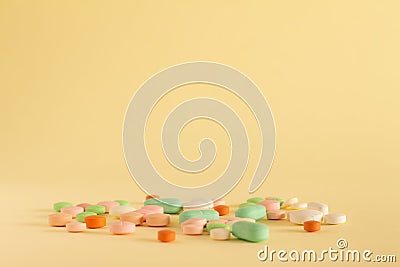 Colored medications on yellow neutral background. Concept of prescription drug abuse. Products of the pharmaceutical industry Stock Photo