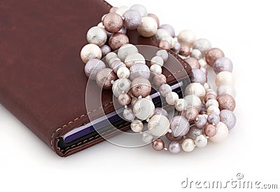 Colored pearls and a mobile phone on a white background. Stock Photo