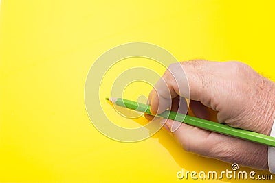 Colored pencil in the hand of an adult person Stock Photo