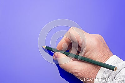 Colored pencil in the hand of an adult person Stock Photo