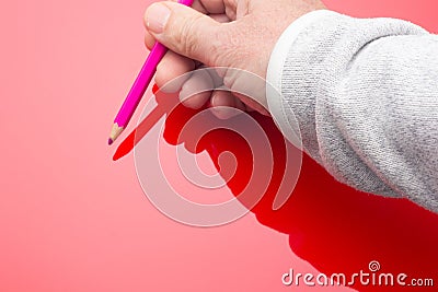 Colored pencil in the hand of an adult person Stock Photo