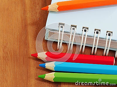 Colored pencils with blank sketch book on wooden background Stock Photo