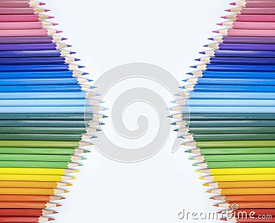 Closeup of colored pencils lined up in a row and abstract shape on background copy space Stock Photo