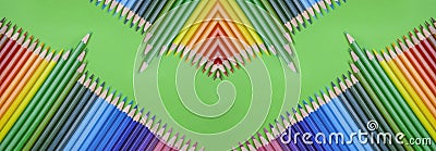 Closeup of colored pencils lined up in a row and abstract shape on background copy space Stock Photo