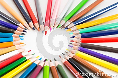 Colored pencils lying around the heart Stock Photo