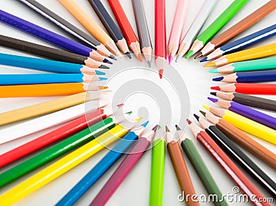 Colored pencils lying around the heart Stock Photo