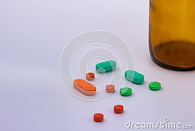 Colored pills. Legal drugs. Medications for humans. Brown glass container Stock Photo