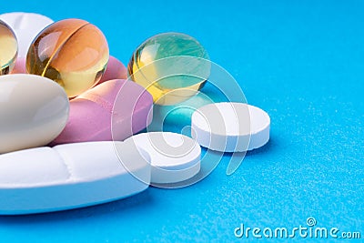 colored pills and multivitamins on a blue background. omega3 Stock Photo