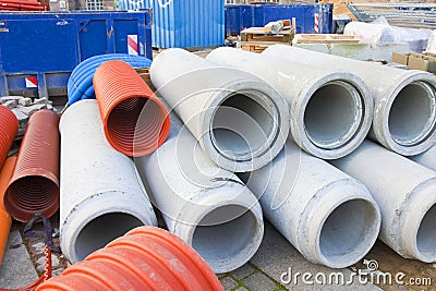 Colored plastic hose and concrete pipe used in the construction industry for plumbing systems or for electrical installations Stock Photo