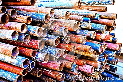 A heap of colored rusty pipes on the street Stock Photo