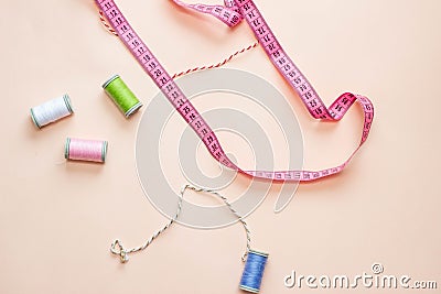 Colored skeins of thread on top of a beige background. Photo in a flat style, the layout of items for sewing. Stock Photo