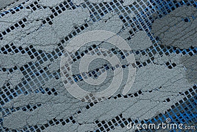 Colored texture of blue plastic mesh and pieces of gray concrete Stock Photo